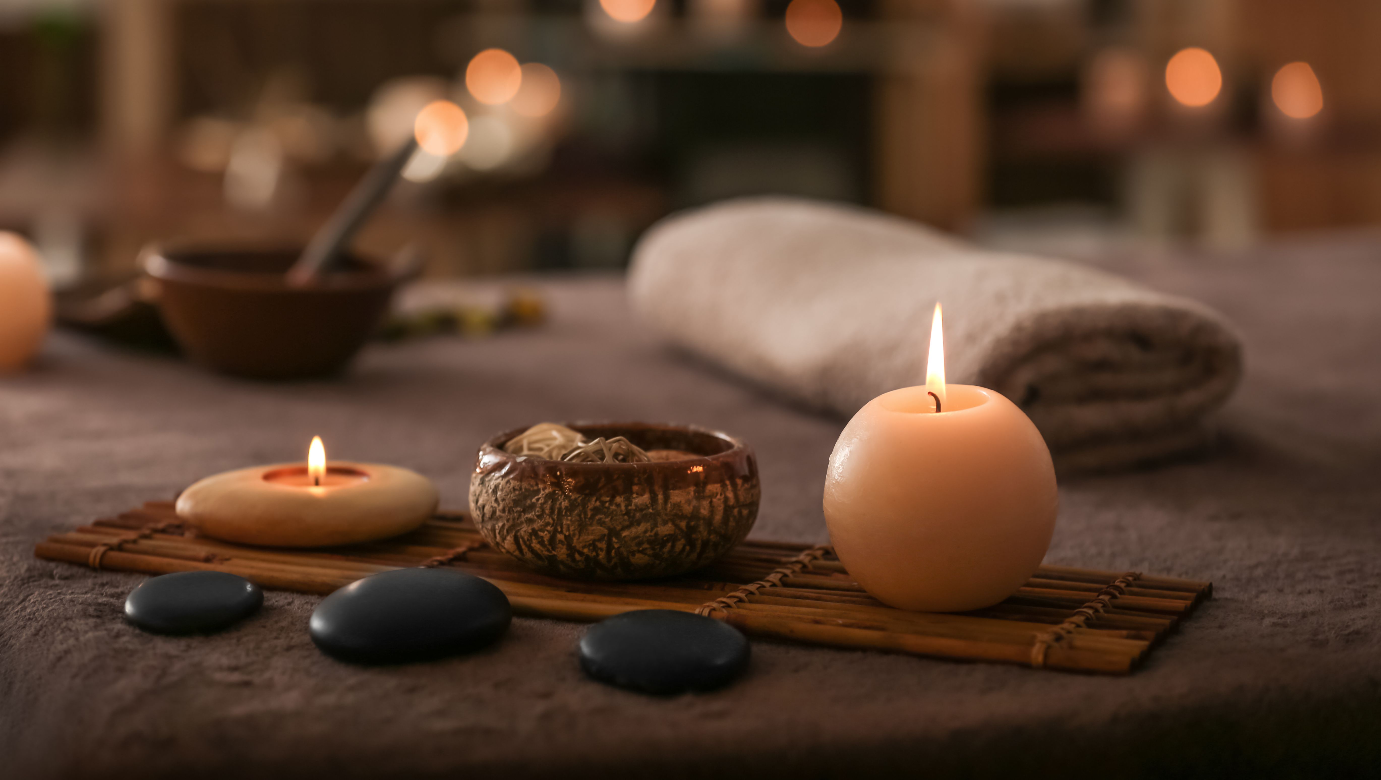 Tända ljus och stenar i massagemiljö